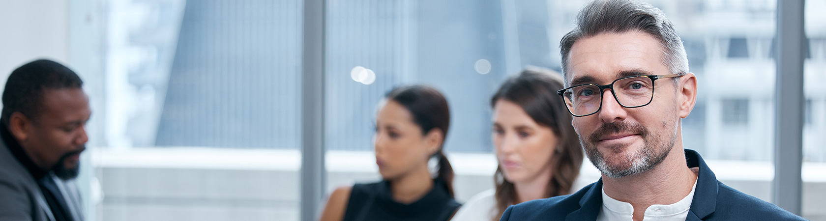 A group of people in an office setting, a man smiles at the camera