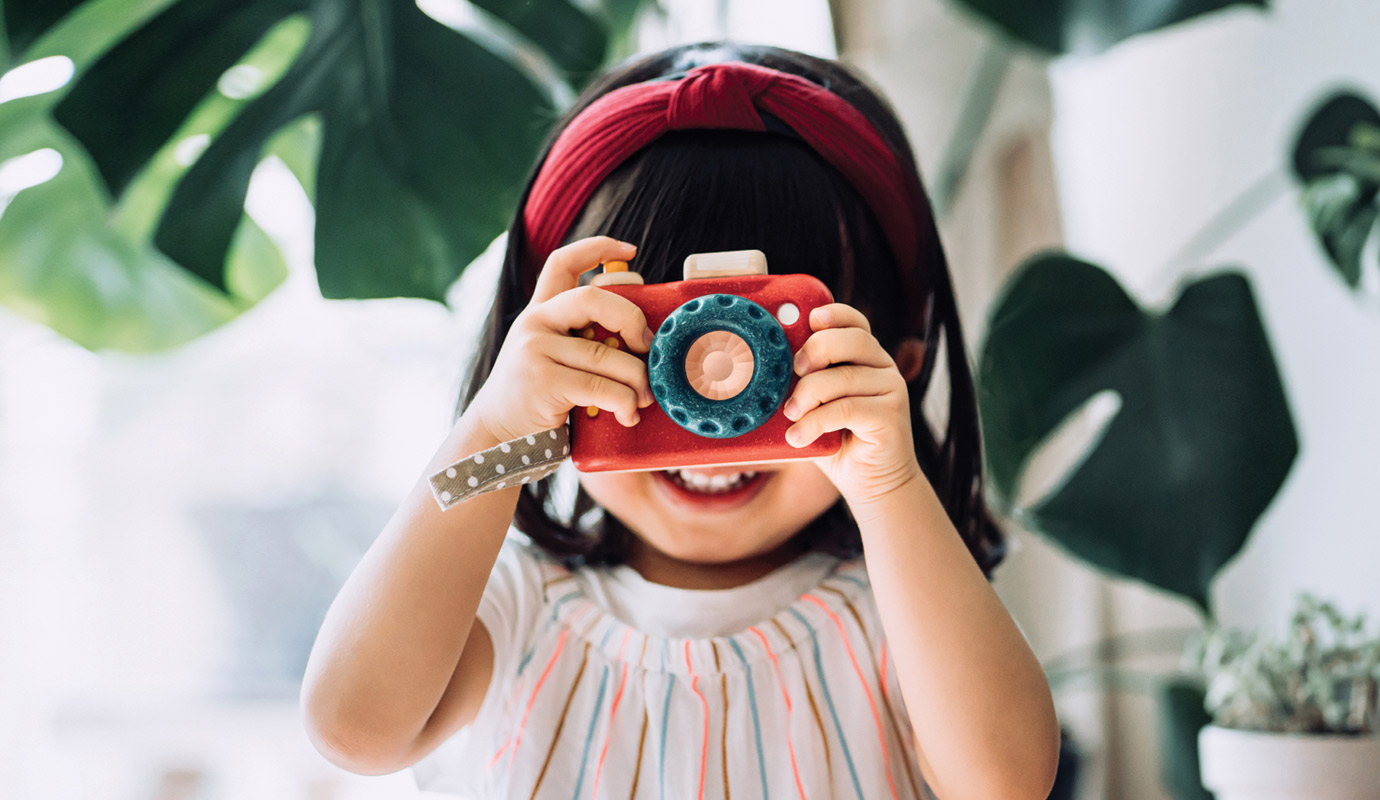 Child holding up a toy camera