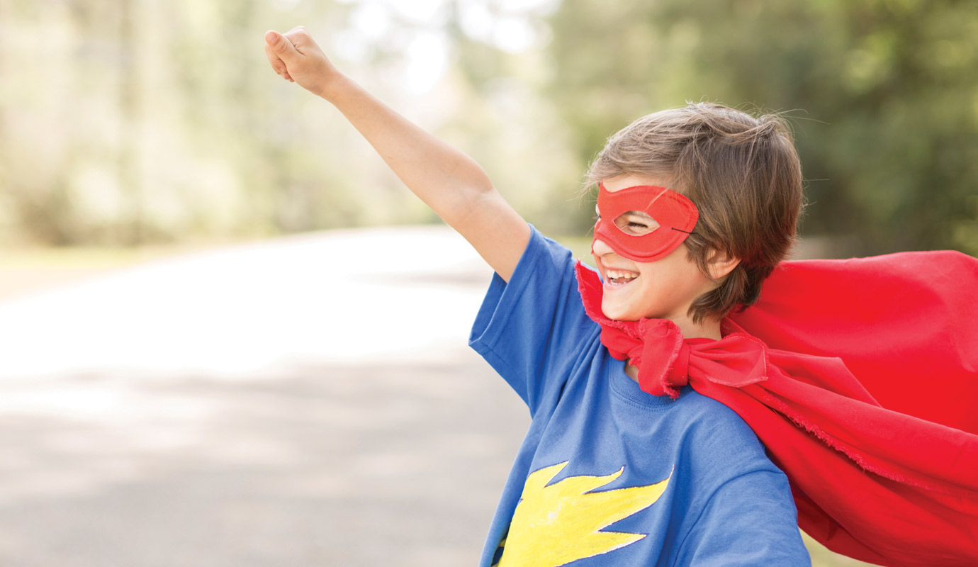 Child is superhero costume pointing their finger