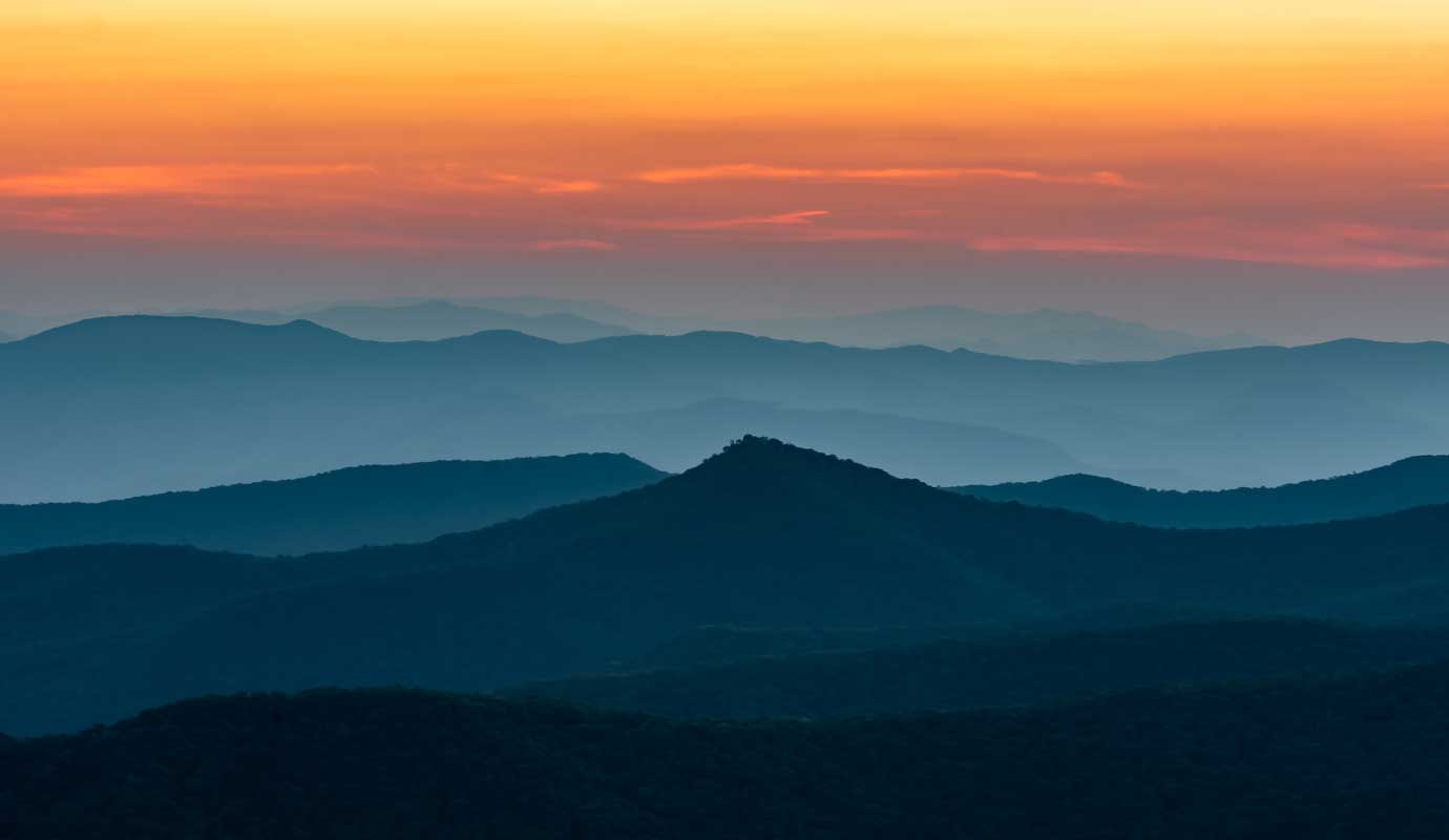 A misty mountain range at sunset