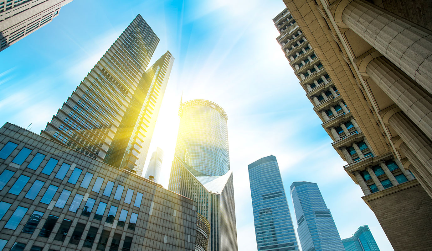 The sun peeking out between skyscrapers