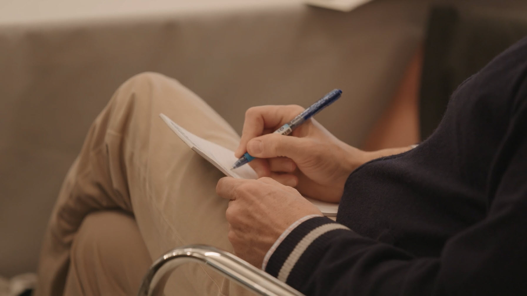man writing on a paper with a pen